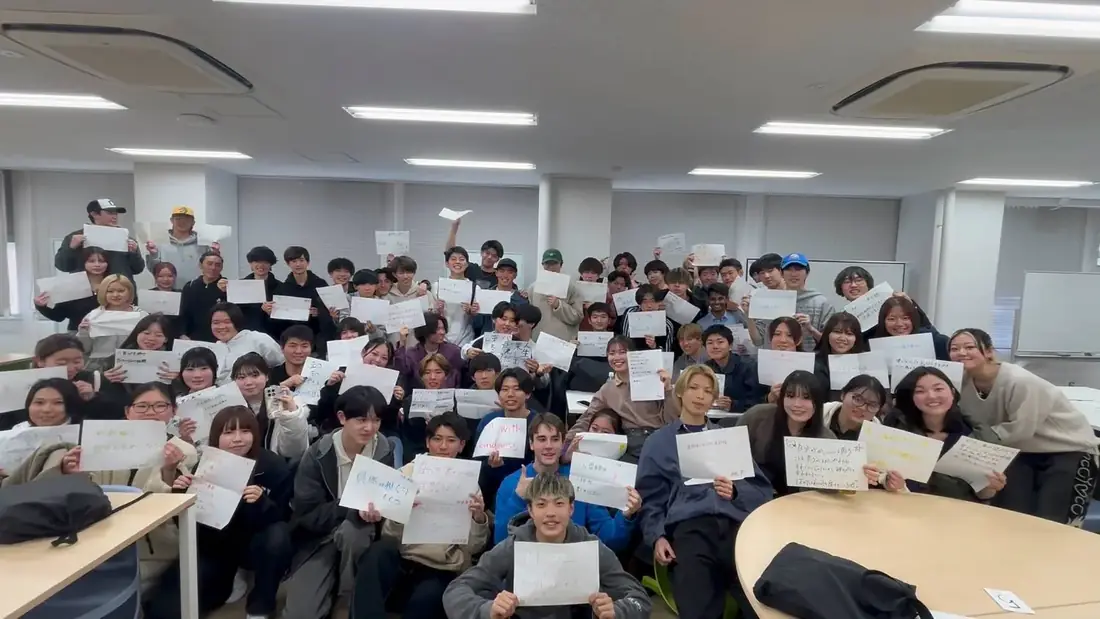 関係構築ワークショップで言葉を書いた紙を掲げる寮生たち
