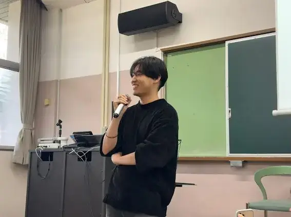 教室でマイクを持って話す石川翔太